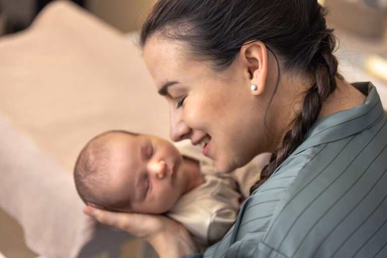 Mother holding newborn baby and providing gentle care after a safe delivery.