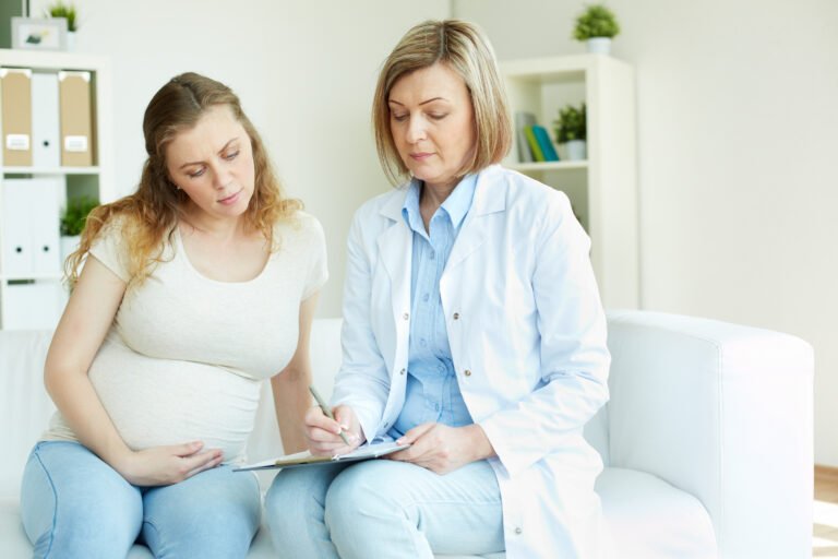 Gynecologist consulting a female patient in clinic